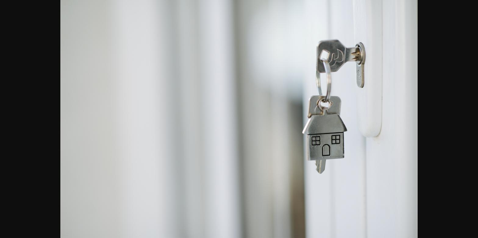 House-shaped key on a keyring in a front door